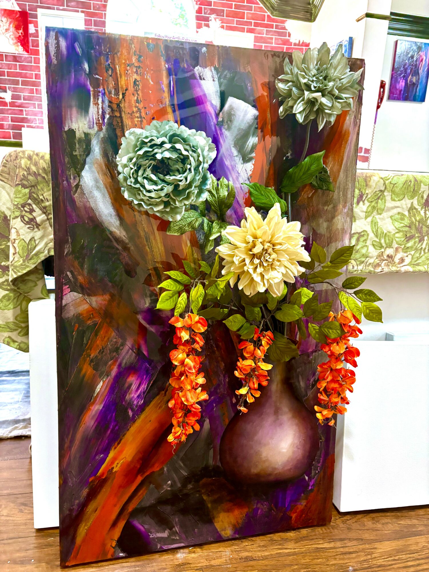Colorful abstract painting with a flower arrangement in a purple vase, including green, yellow, and orange flowers, indoors.