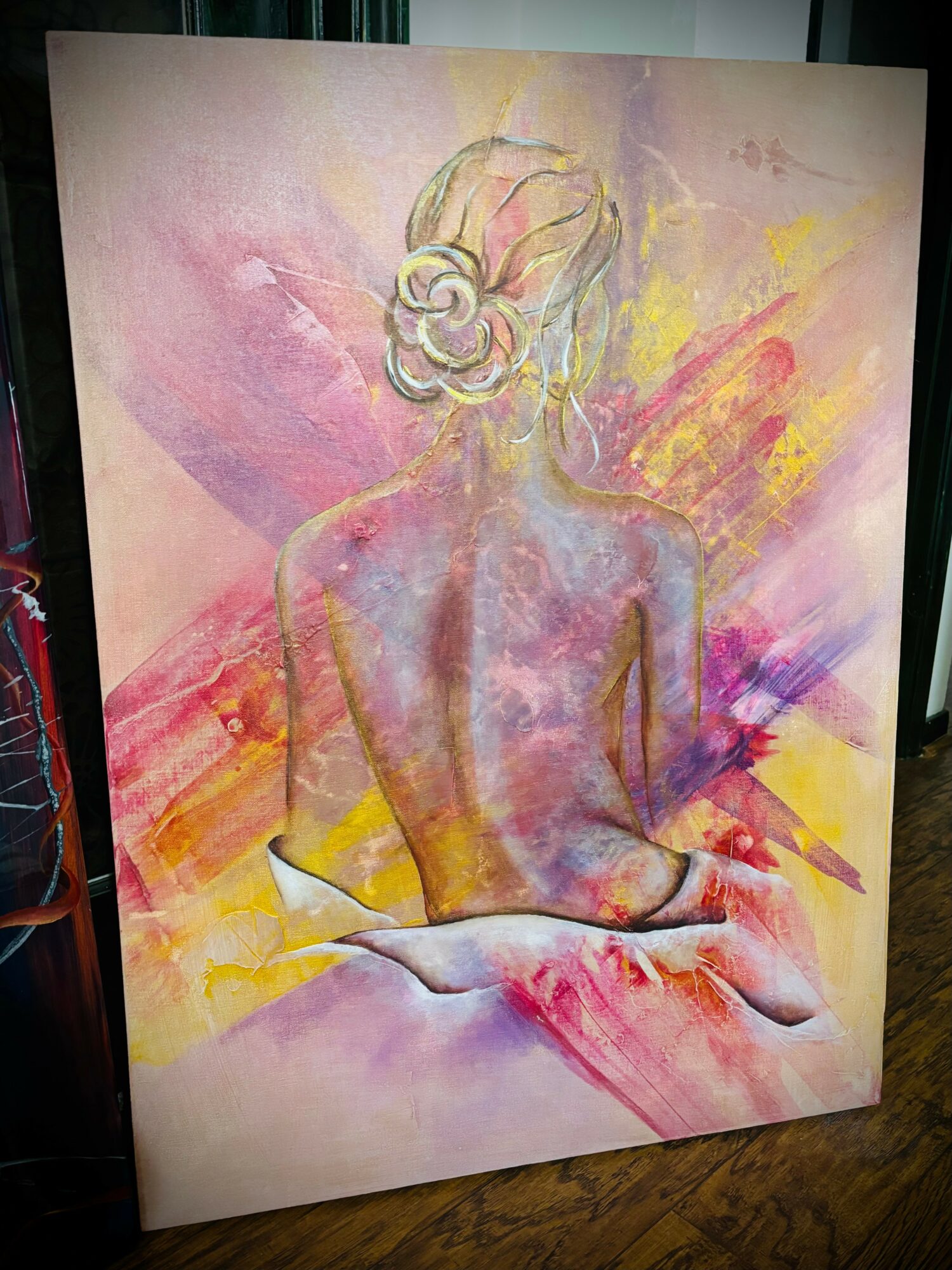Watercolor painting of a woman with headphones, back view, sitting with arms crossed, surrounded by colorful abstract background.