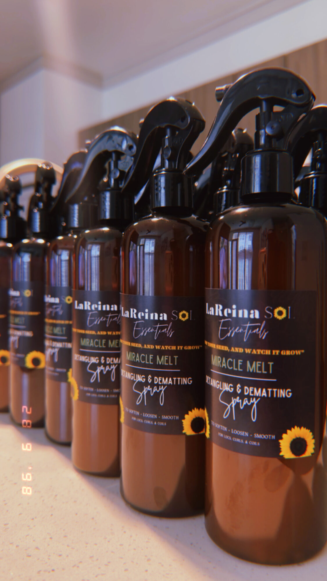 Row of brown spray bottles with black spray nozzles on a shelf, labels partially visible.
