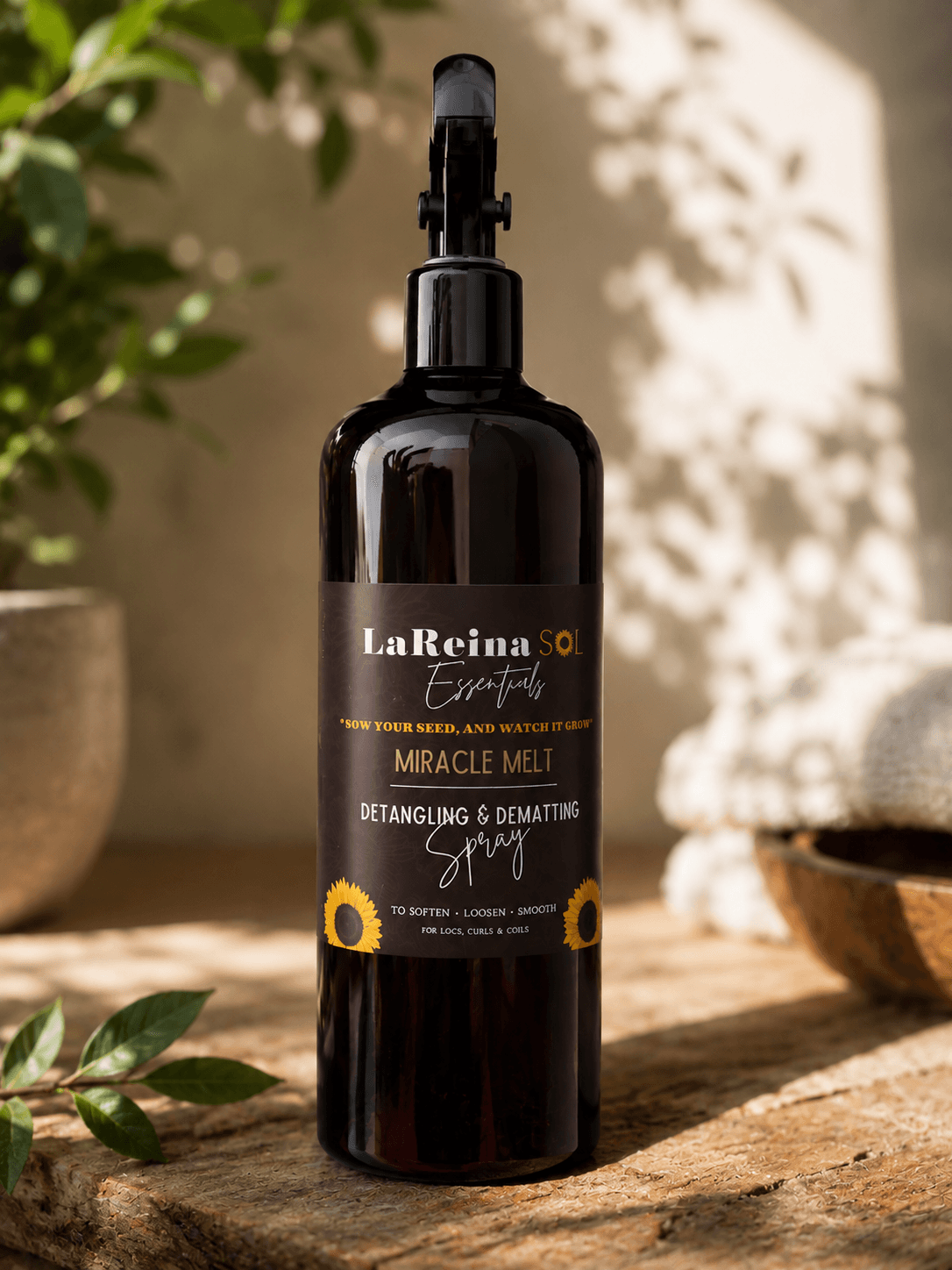 Black spray bottle labeled La Reina del Tepezcohuite Miracle Melt, placed on a wooden surface outdoors with sunlight and shadows.