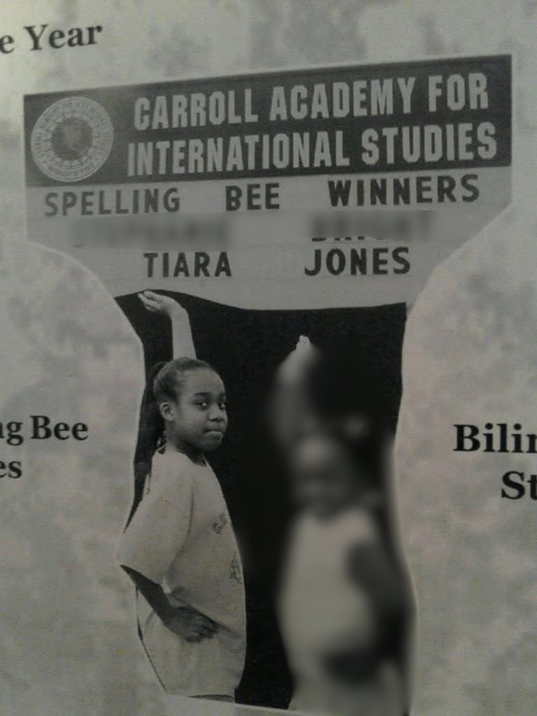 Young girl standing in front of a sign for Carroll Academy for International Studies, with text about spelling bee winners, and blurred people in the background.