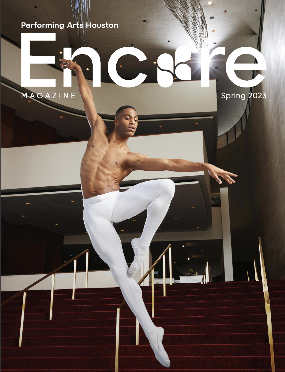 Ballet dancer in white tights performs on stairs inside a modern building, arms extended, one leg raised, focused expression.