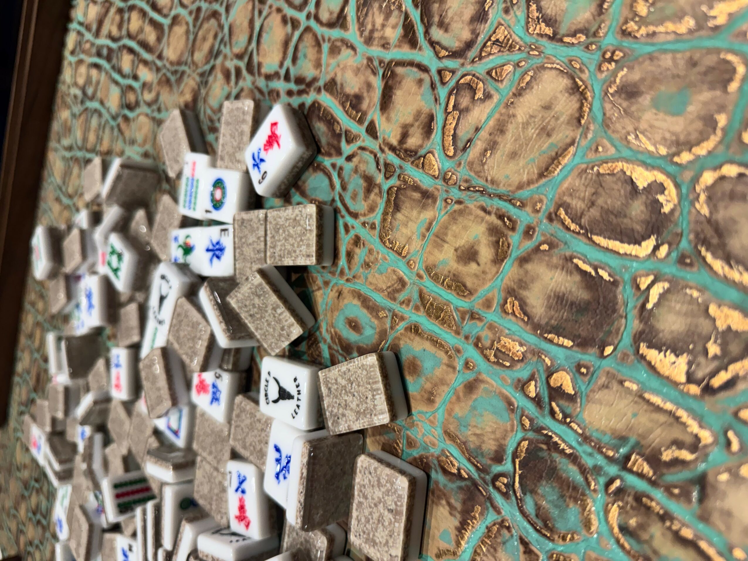 Small rectangular blocks with symbols and letters are scattered on a textured surface with a pattern of lines and shapes.