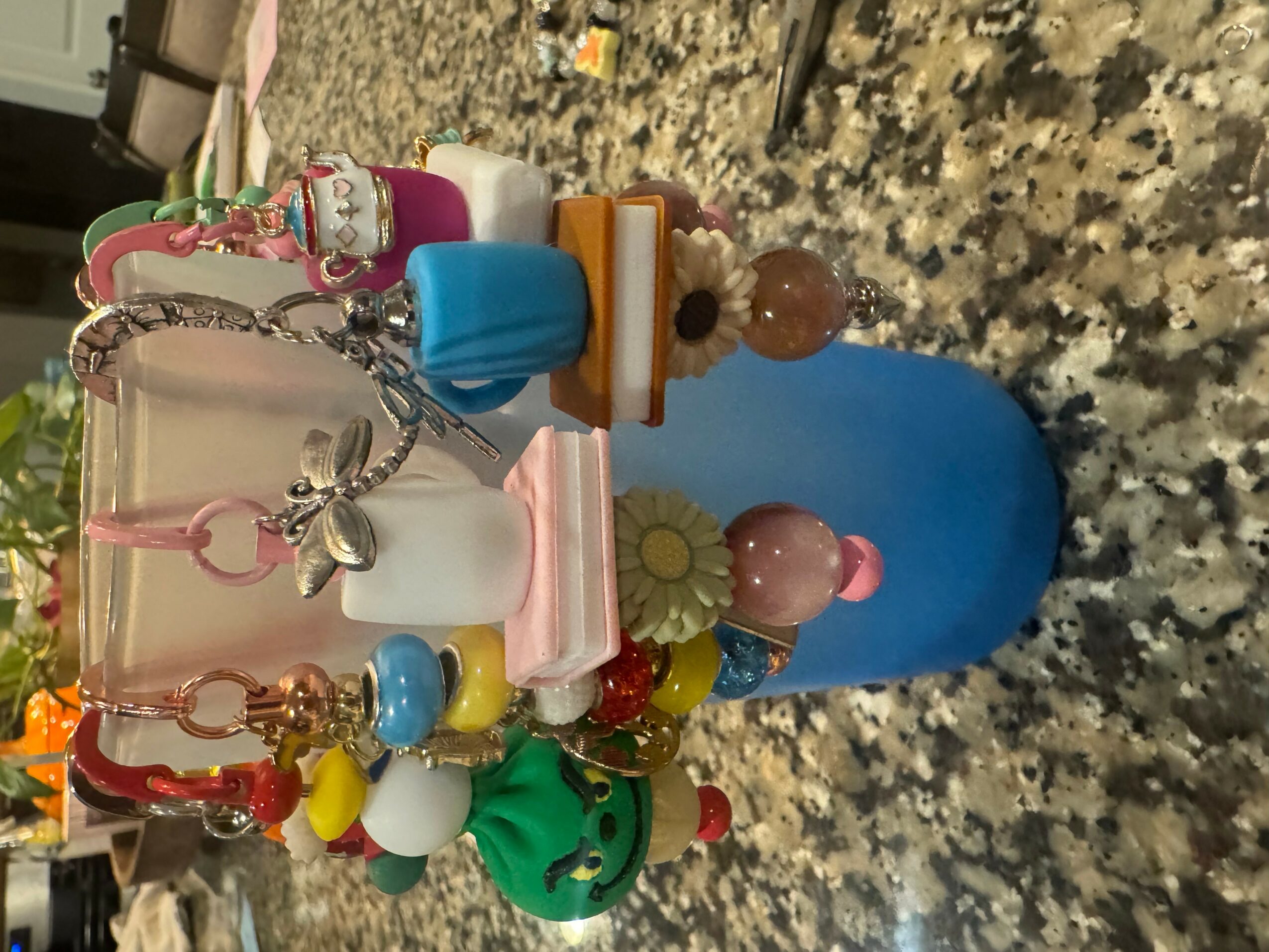 Collection of colorful keychains and small objects on a speckled surface.