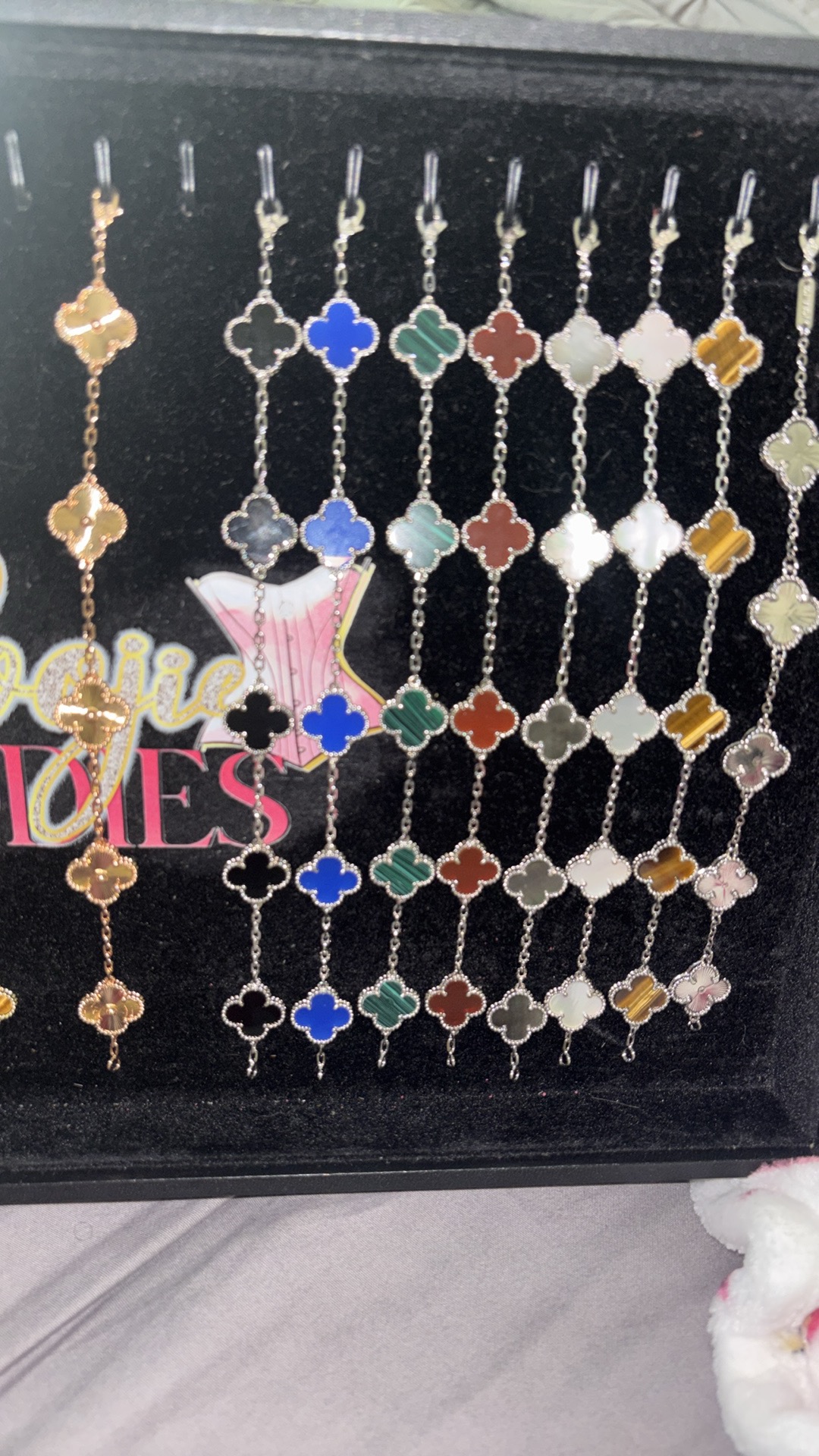 Display of colorful keychains with various shapes and patterns, arranged in rows inside a box.