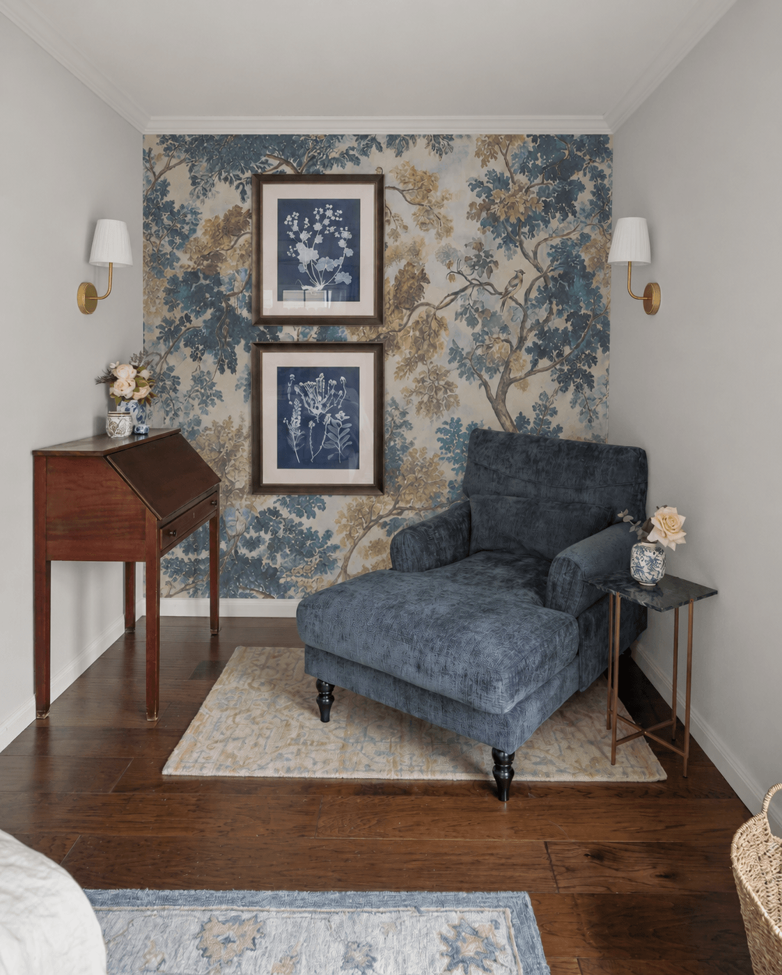 Cozy reading nook with a blue armchair, wall art, side table with flowers, and a decorative rug.