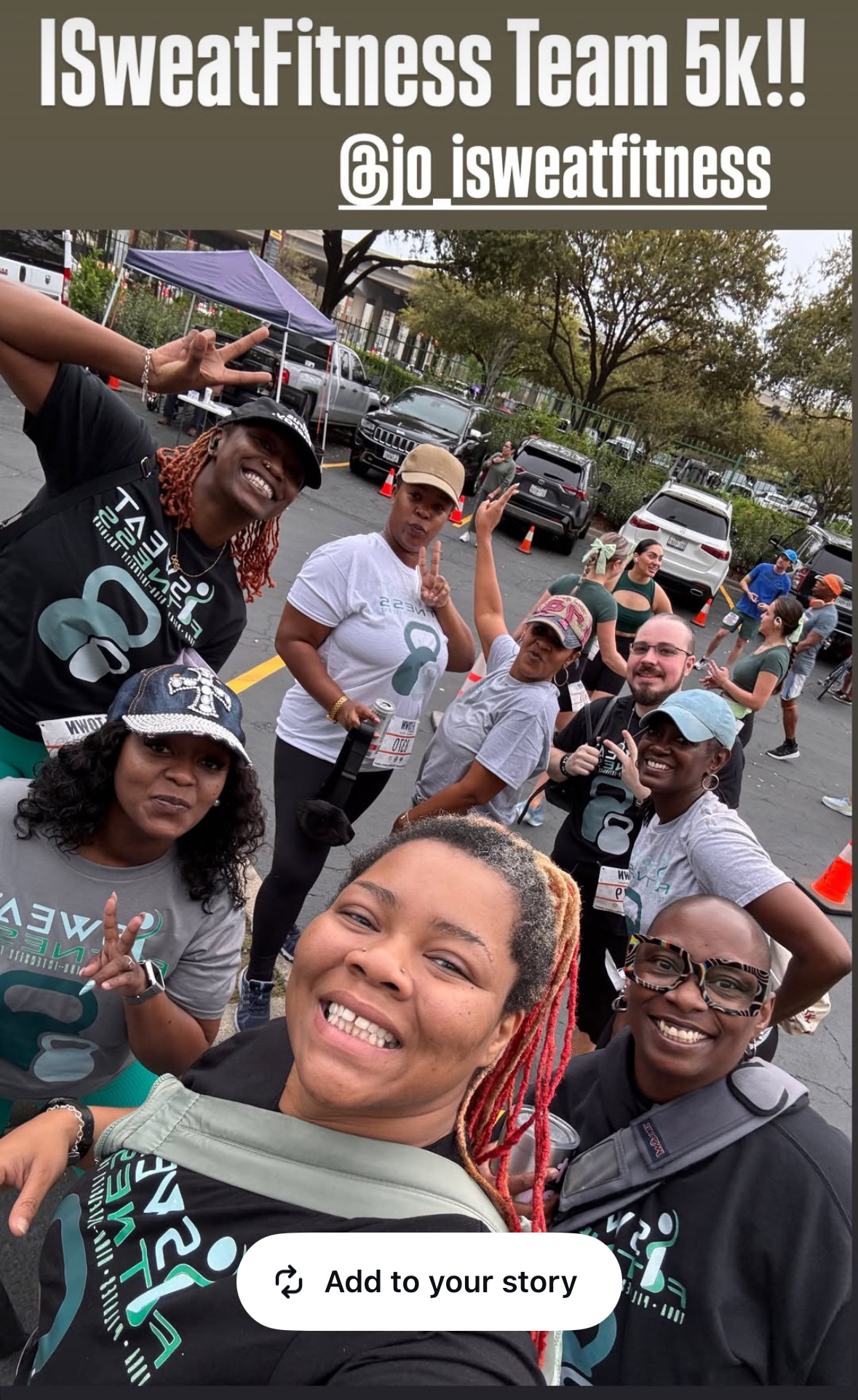 Group of smiling people outdoors, some wearing athletic gear, celebrating after a fitness event, with trees and cars in background.